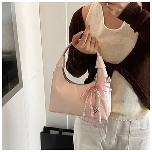 Petit sac demi-lune rose avec nœud, chaîne de perles et breloque cœur en détail