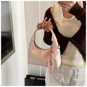 Sac à bandoulière rose brillant avec un nœud à carreaux et des breloques en perles