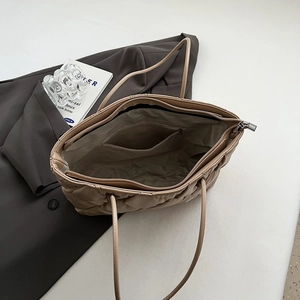 Detail shot of khaki quilted tote bag interior with zipper closure and smooth lining