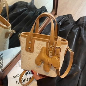 Fashionable beige star embossed bucket bag with brown trim and cute animal charm