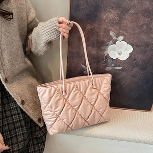 Close-up of pink quilted puffer tote bag featuring elegant diamond lattice stitching details