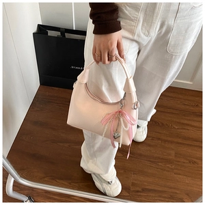 Détail du petit sac carré rose avec chaîne en perles et pendentif en cœur