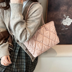 Pink quilted tote bag on model side view showing the large diamond stitch and soft texture
