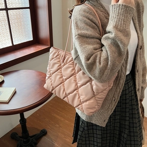 Pink quilted puffer tote bag in lightweight nylon fabric shown on model shoulder