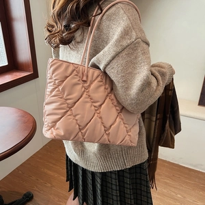 Detailed view of pink quilted tote bag with soft padded texture and shoulder strap