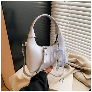 Détail du sac hobo blanc mat avec breloque perle et accessoire nœud à carreaux bleus