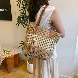 Large woven straw beach tote bag with leather straps and tassel for seaside vacation style