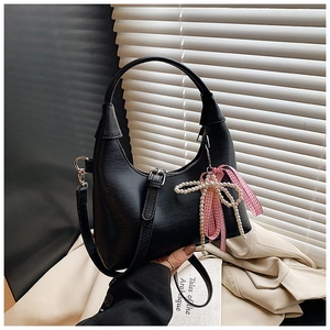 Détail du sac demi-lune noir avec nœud en perles et ruban à carreaux élégant
