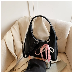Détails du sac selle noir en similicuir texturé avec breloque en perles et ruban rose
