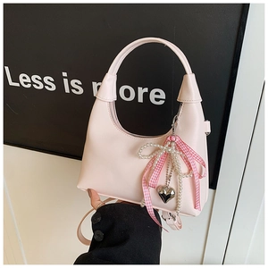 Détail du sac à main demi-lune rose avec breloque perle et nœud à carreaux