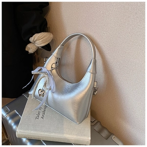Détail du sac Hobo argenté avec nœud en perles et pendentif en forme de cœur