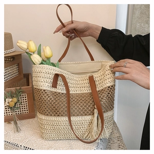 Detail of hand-woven straw tote with brown leather handles and striped texture