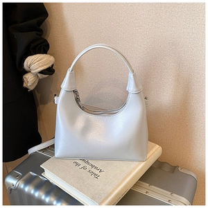 Détail d'un sac à main argenté minimaliste avec poignée intégrée et texture lisse mate