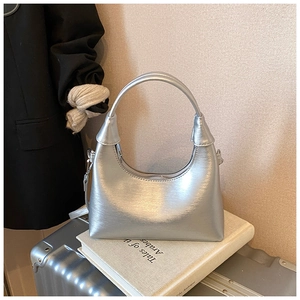 Gros plan d'un sac à main argenté en demi-lune avec texture métallique et anse arquée
