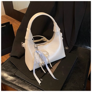 Détail du sac lune en similicuir blanc crème avec chaîne perle et nœud décoratif