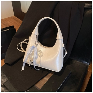 Détail du sac hobo blanc brillant avec ruban bleu et pendentif en forme de cœur perlé