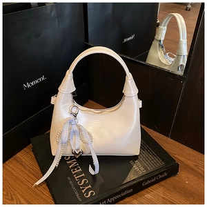 Détail du sac demi-lune blanc crème fini perlé avec ruban à carreaux et breloque cœur
