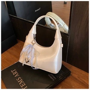 Détail du sac demi-lune blanc nacré avec nœud bleu et chaîne de perles décorative