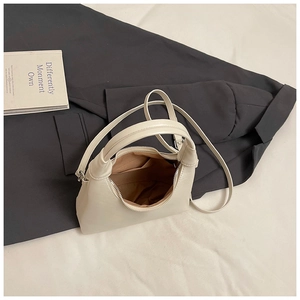 Vue intérieure du sac carré crème minimaliste montrant la doublure et la poche zippée