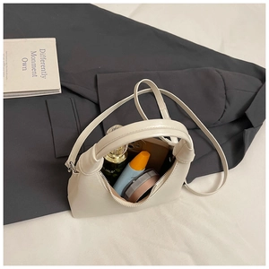 Détail de l'intérieur du sac à main blanc crème montrant la capacité pour les essentiels