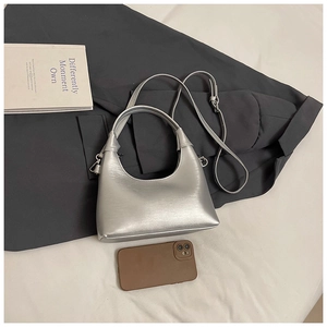 Détail du sac à main argenté brossé avec bandoulière réglable et smartphone de référence