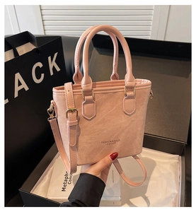 Pink matte leather bucket bag with gold hardware and removable shoulder strap