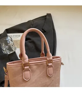 Pink textured fabric handbag detail with smooth round handle and gold metal hardware
