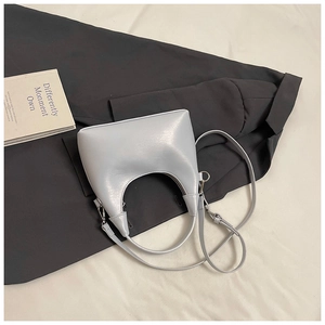 Détail du sac à main minimaliste bleu-gris clair avec poignée en croissant et ferrures argentées
