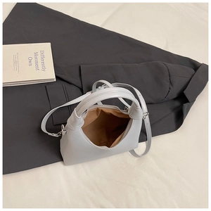 Vue de dessus du sac à main en cuir gris clair avec doublure et bandoulière réglable