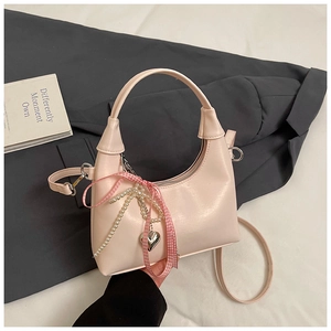 Détail du sac demi-lune rose clair avec nœud, perles et bandoulière réglable
