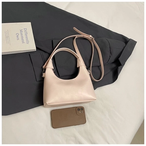 Détail du sac carré en cuir rose poudré montrant la texture mate et les boucles argent