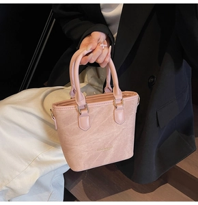 Detail of pink suede tote bag with leather trim and Fashion & Bag printed text