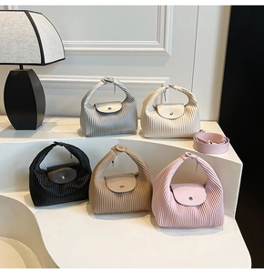 Detail showing various colors of pleated textured handbags with detachable shoulder straps