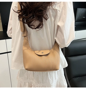 Detail of beige pleated shoulder bag featuring elegant texture and minimalist silhouette