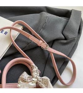Detail der rosa Handtasche aus Kieselleder mit Seidenschal und verstellbarem Riemen