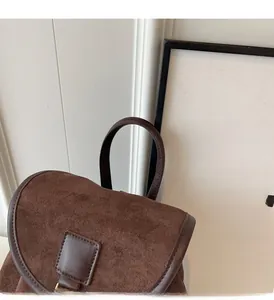Close-up of the vintage brown matte suede backpack handle and reinforced leather flap detail