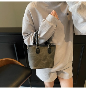 Detail view of the silver hardware fasteners and marble texture on the leather bucket bag