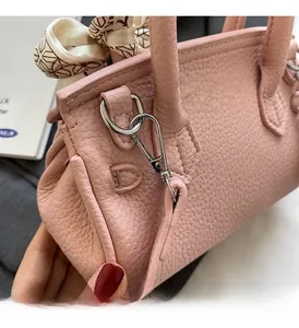 Detail der rosa Handtasche aus Leder mit Seidenschal und silbernen Metallbeschlägen