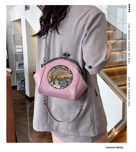 Detail of pink shell-shaped bag with elephant relief and vintage metal clasp