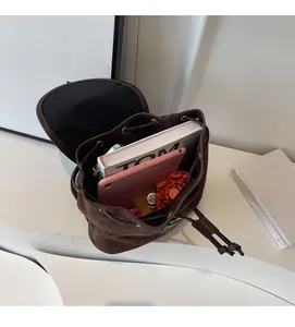 Top view of spacious brown suede backpack showing tablet, books and daily essentials