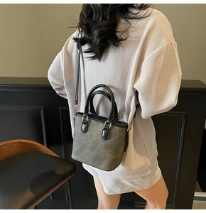 Olive green bucket bag detail showing the adjustable strap and golden fashion text