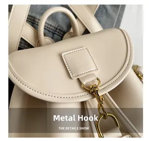 Close-up of golden metal hook and textured cream leather on a stylish backpack