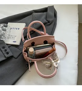 Draufsicht auf das Innere einer rosa Lederhandtasche mit viel Stauraum für Utensilien