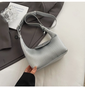 Detail of silver pleated hobo bag featuring metallic texture and adjustable shoulder strap