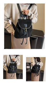 Detail view of black frosted suede backpack featuring gold metal buckle and drawstring closure