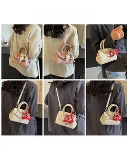Detail von rosa und cremefarbenen Mini-Handtaschen mit Seidenschal-Griff und Metallschnalle