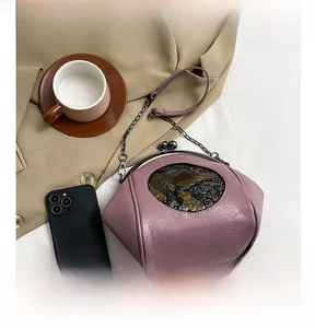Macro detail of purple vintage seashell bag with embossed elephant coin and metal chain