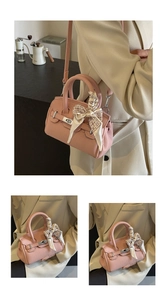 Detail der rosa Handtasche aus Leder mit Seidenschal am Griff und silbernem Drehverschluss