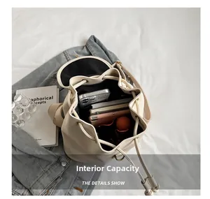 Macro detail of spacious interior capacity for cream drawstring bucket backpack with items
