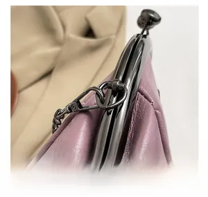 Macro view of metallic buckle and chain hook on pink leather shell-shaped bag